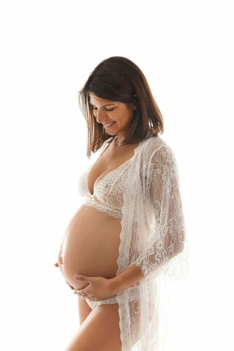 Femme enceinte en déshabillé blanc