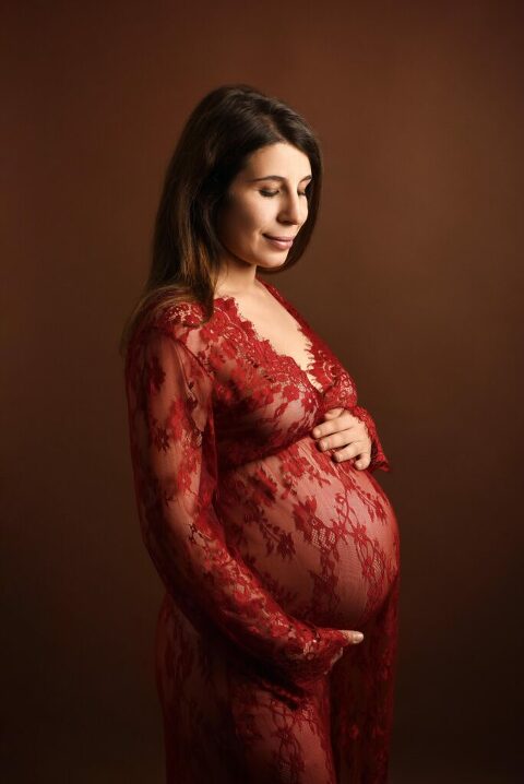 Femme enceinte portant une robe rouge en dentelle