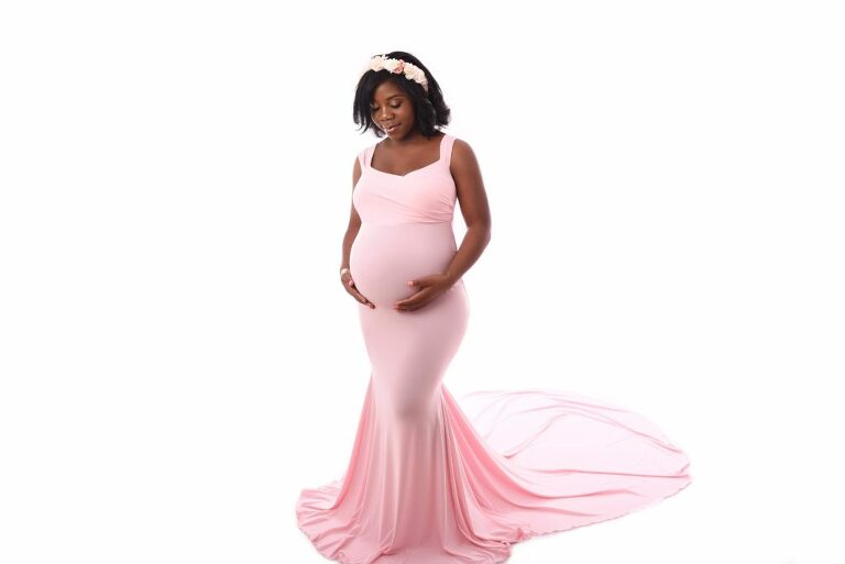 Femme enceinte en robe rose et une couronne de fleurs