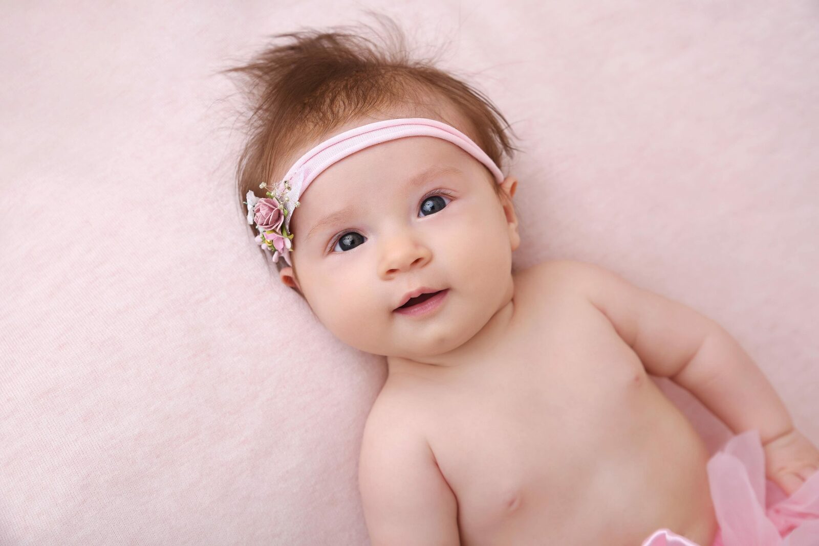 Petite fille de 2 mois allongée sur une couverture rose