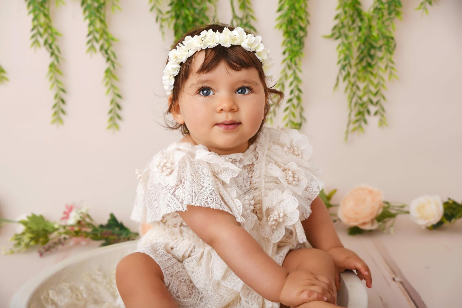 Portrait d'un bébé en robe et couronne de fleurs