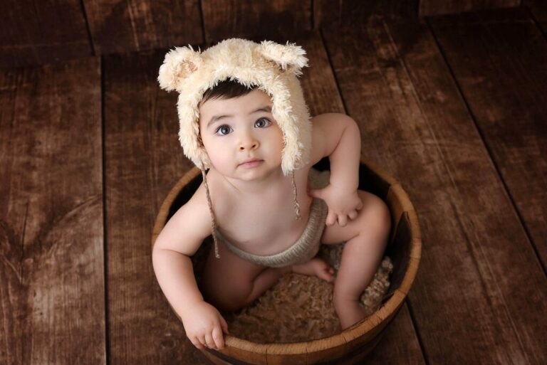 Bébé assis dans un tonneau en bois
