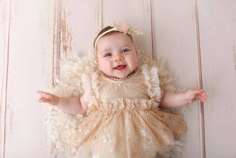 Petite fille souriante en robe allongée sur le dos